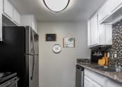 Thumbnail 27 of 30 - a kitchen with stainless steel appliances and white cabinets