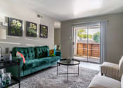Thumbnail 28 of 30 - a living room with a green couch and a sliding glass door