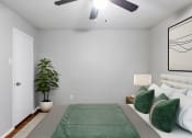 Thumbnail 4 of 15 - a bedroom with a bed and a plant and a ceiling fan