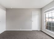 Thumbnail 30 of 31 - an empty room with a carpeted floor and two windows