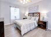 Thumbnail 8 of 12 - A bedroom with a large bed and a ceiling fan.