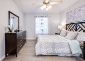 Thumbnail 7 of 12 - A bedroom with a large bed and a dresser with a mirror above it.