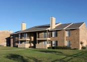 Thumbnail 2 of 3 - a brick apartment building with balconies and a lawn  at Wymberly Pointe, Grand Prairie, TX, 75052
