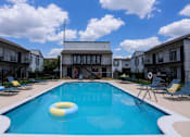 Thumbnail 6 of 27 - A swimming pool with a yellow and blue float in the middle.