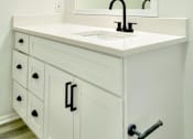 Thumbnail 27 of 31 - A white bathroom vanity with a sink and mirror.