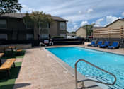Thumbnail 5 of 31 - A pool with a metal ladder and a bench outside a building.