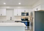 Thumbnail 17 of 31 - A modern kitchen with stainless steel appliances and white cabinets.