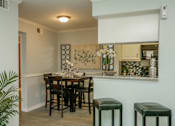 Thumbnail 5 of 12 - A dining room with a table and chairs.