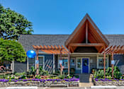 Thumbnail 4 of 10 - A house with a blue door and a wooden roof with a pergola.