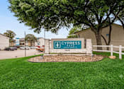 Thumbnail 1 of 31 - A sign for Cypress Apartment's 1505 is in front of a building.