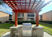 Thumbnail 2 of 31 - an outdoor kitchen with a grill and a pergola in front of an apartment building  at The Alara, Houston