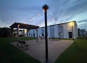 Thumbnail 4 of 27 - A park with a bench and a pole with lights.