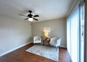Thumbnail 2 of 13 - A room with a ceiling fan and two chairs.