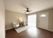 Thumbnail 1 of 13 - an empty living room with a ceiling fan and a door to a balcony