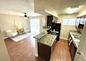 Thumbnail 4 of 13 - A kitchen with a black refrigerator and brown cabinets.