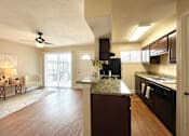 Thumbnail 5 of 13 - A kitchen with dark wood cabinets and a marble countertop.