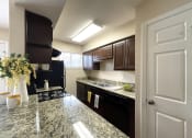 Thumbnail 3 of 13 - a kitchen with black appliances and granite counter tops
