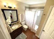 Thumbnail 9 of 13 - A bathroom with a sink, toilet, and shower.