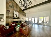 Thumbnail 1 of 16 - a living room with leather furniture and a stone wall