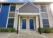 Thumbnail 5 of 16 - a building with two blue doors and a porch