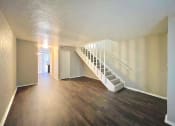 Thumbnail 14 of 16 - an empty living room with a staircase and wood floors