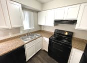 Thumbnail 13 of 16 - a kitchen with black appliances and white cabinets