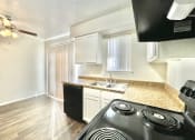 Thumbnail 9 of 16 - an empty kitchen with a stove and a sink