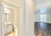 Thumbnail 11 of 16 - an empty living room and bathroom with hardwood flooring