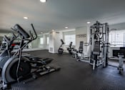 Thumbnail 8 of 27 - A spacious gym with a variety of equipment including a treadmill, weights, and a bench press.