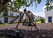 Thumbnail 11 of 27 - A playground with swing set.