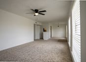 Thumbnail 16 of 27 - A room with a ceiling fan and carpeted floor.