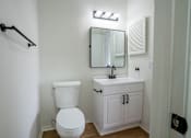 Thumbnail 24 of 27 - A white toilet sits next to a sink in a half-bath.