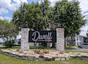 Thumbnail 1 of 27 - A sign for Dwell is in front of a building.