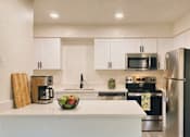 Thumbnail 18 of 31 - A kitchen with white cabinets and a black refrigerator.