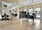 Thumbnail 9 of 12 - A spacious room with a dining table and chairs.