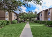 Thumbnail 2 of 31 - A long concrete walkway separates two rows of apartment buildings.