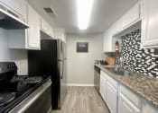 Thumbnail 21 of 30 - a kitchen with white cabinets and black appliances  at 2151 Kirkwood, Texas