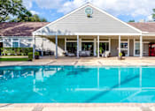 Thumbnail 2 of 15 - A house with a pool in front.