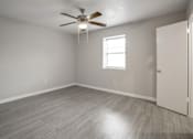 Thumbnail 11 of 15 - A room with a ceiling fan and a window.