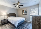 Thumbnail 5 of 10 - A bedroom with a bed, nightstand, and a ceiling fan.