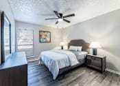 Thumbnail 8 of 10 - A bedroom with a bed, nightstand, and a ceiling fan.