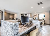 Thumbnail 11 of 31 - A modern kitchen with a marble island and a computer on it.