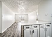 Thumbnail 21 of 31 - A kitchen with white cabinets and a counter top.