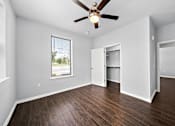 Thumbnail 5 of 7 - Empty bedroom with hardwood floors and window at The Aurea Apartments, Texas