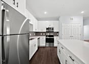 Thumbnail 1 of 7 - Modern galley kitchen with stainless steel appliances at The Aurea Apartments, Houston, TX 77093