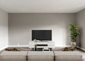 Thumbnail 31 of 31 - A living room with a television, sofa, and potted plant.