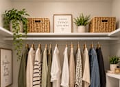 Thumbnail 13 of 14 - Clothes hanging on a rack in a room.