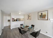 Thumbnail 5 of 15 - A dining room with a glass table and chairs.