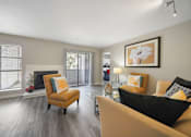 Thumbnail 8 of 15 - A living room with a yellow chair and a black couch.