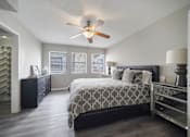 Thumbnail 13 of 15 - A bedroom with a bed, dresser, and ceiling fan.